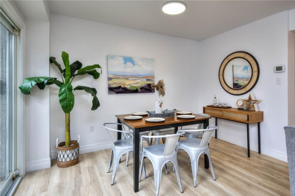 A tastefully arranged table set, featuring a picture frame, a plant with a creative design, and a mirror, artistically staged by Helen's Team.