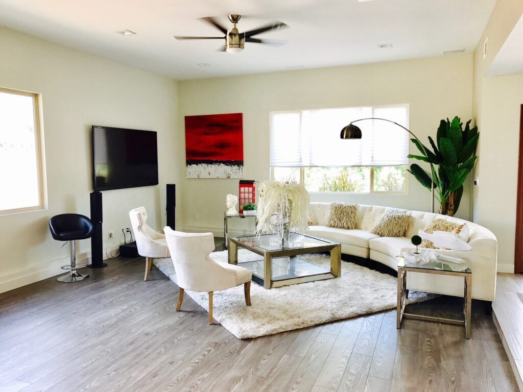 A well-designed living room featuring a spacious layout with a white couch as the focal point, complemented by tasteful accent pieces.