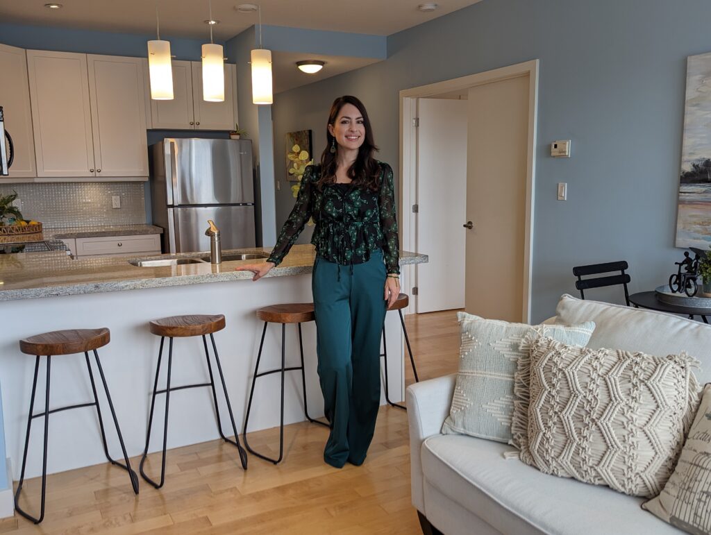 Helen expertly arranges the kitchen space in a meticulously staged property, surrounded by stylish stools that complement the inviting ambiance.
