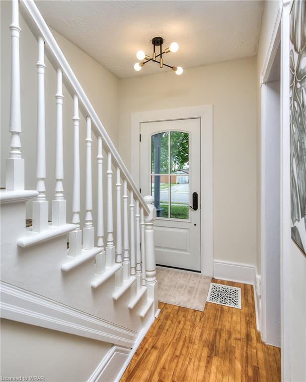 A welcoming house entrance featuring a crisp white door, elegant wooden flooring, and a harmonious blend of neutral colors.